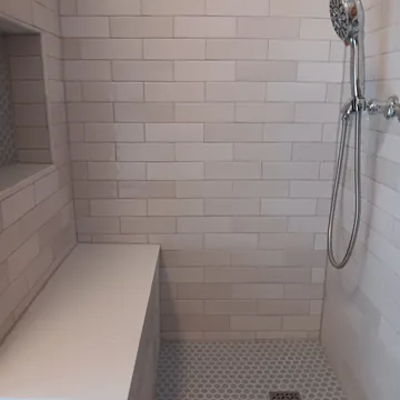 Walk-in shower with custom tilework and built-in bench from a Lake Leelanau bathroom remodel