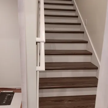 Completed custom staircase with stained wood, trim, and safety railing in Leelanau County